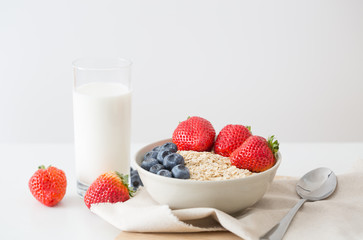 Oatmeal with fresh fruit and milk. Strawberry and blueberry.