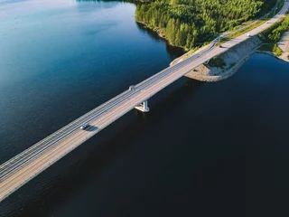 Poster Aerial view of bridge across blue lake in summer landscape in  Finland © nblxer