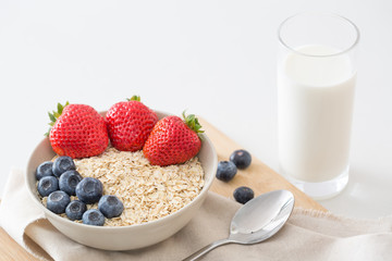 Oatmeal with fresh fruit and milk. Strawberry and blueberry.