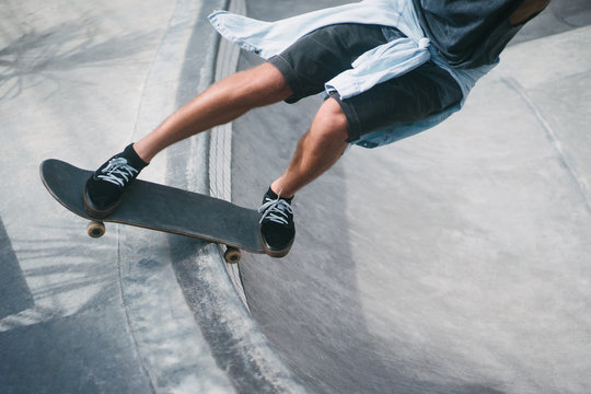 cropped image of skater skating on longboard at skatepark
