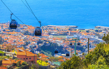 Traditional cable car transporting tourists above Funchal city of Madeira island, Portugal