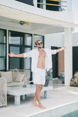 smiling man standing with open arms at resort in Bali, Indonesia