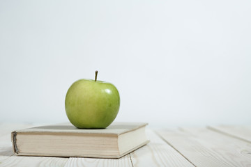 Stack of books and apple on the table. Copy space for text. Selective focus. Knowledge concept