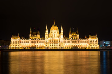 Naklejka premium Famous Budapest parliament at the river Danube at night from the front