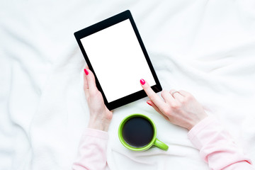 girl uses tablet pc, women's hands, red manicure, lying on the blanket, white background with copy space, for advertising, top view