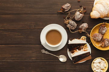 Coffee cup and sweets on vintage wooden table, top view