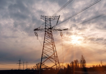 High-voltage power lines at sunset. Electricity distribution station