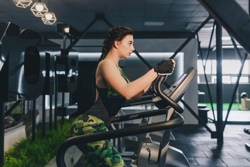 Fototapeta premium Girl working on the stepper in the gym. Healthy lifestyle. Fitness concept.