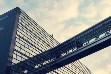 A beautiful, modern, mirrored building. The view from below. Sky with clouds. Corporate building.