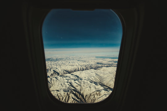 Fototapeta Mountains view through window of aircraft