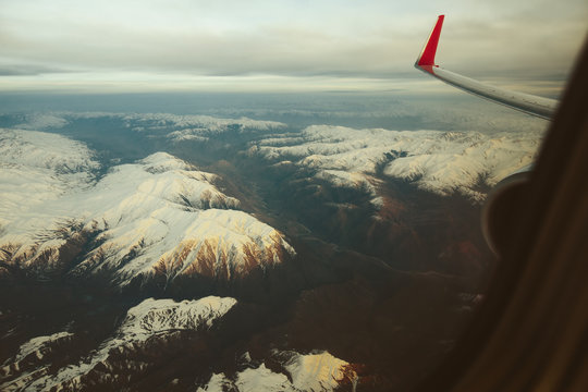 Fototapeta Mountains view through window of aircraft