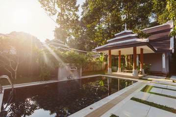 Private swimming pool with alcove, sunbeds and exotic palm trees near luxury villa