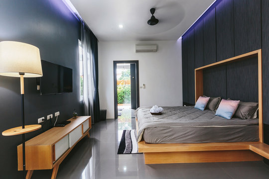 Modern bed room interior in Luxury villa. Big window, fun TV, gray colours