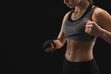 Athletic boxer wrapping hands with boxing bandage