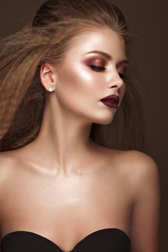 Beautiful blond model: curls, bright makeup and red lips. The beauty face.