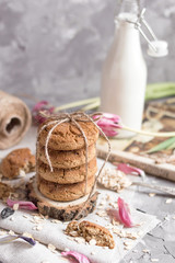 Delicious oatmeal cookies with milk on the light concrete background.