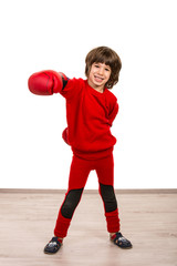 Cheerful boy showing his fist in boxing gloves