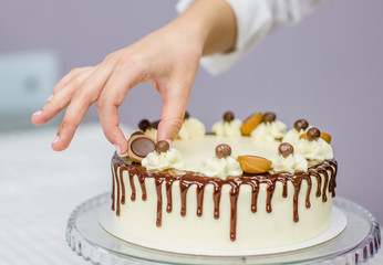 woman decorating chocolate cake in the kitchen