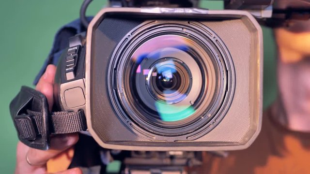 Camcorder is getting directed towards the viewer by a male operator