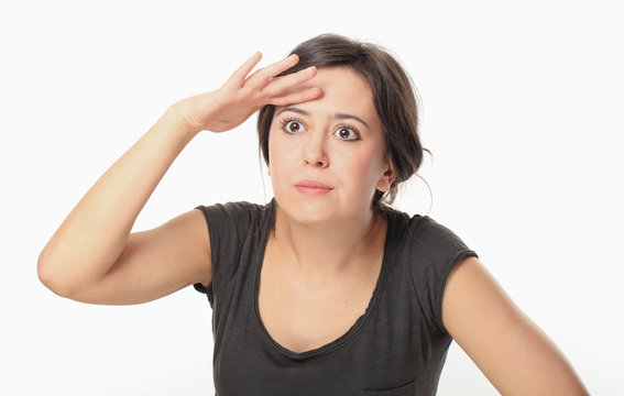 Young woman in T-shirt covering her eyes to search for something
