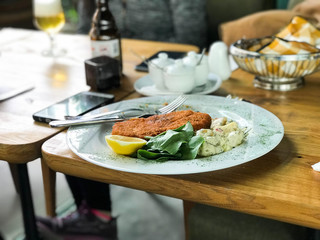 Chicken Schnitzel with potato salad and lemon served at restaurant
