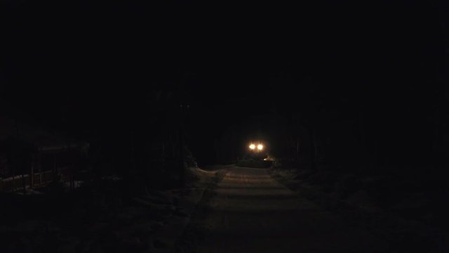Snow cat grooming machine at night.