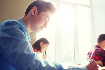 Fototapeta premium education, learning and people concept - group of students with books writing school test