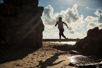 Silhouete woman running at beach