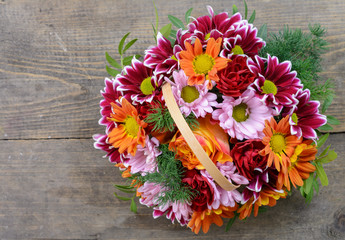 basket with flowers on the background of the old boards