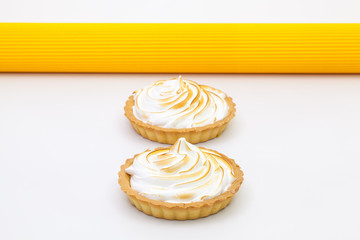 Two lemon tartalets on the white desk