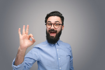 Man in glasses gesturing OK