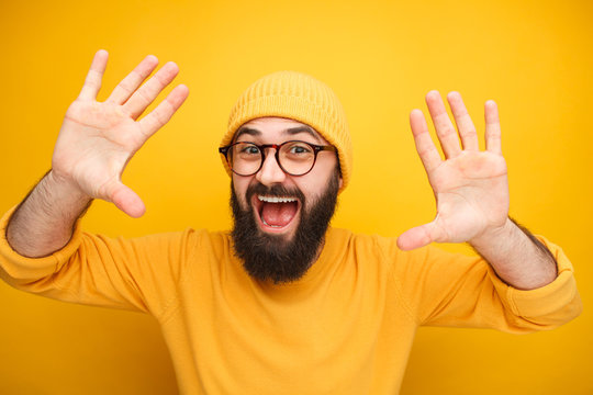Excited bearded man with hands up
