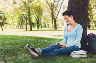 Young woman typing on mobile outdoors