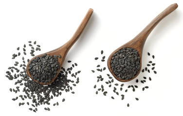 black sesame seeds in the wooden spoon, isolated on white, top view