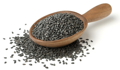 black sesame seeds in the wooden spoon, isolated on white