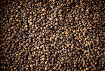 Peppercorn background. Dry black pepper seeds. Top view.