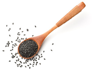black sesame seeds in the wooden spoon, isolated on white, top view
