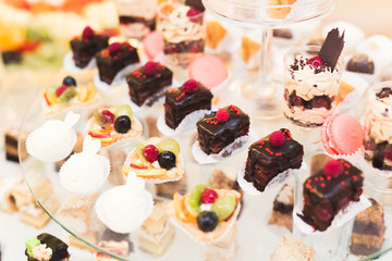 Delicious sweets on wedding candy buffet with desserts, cupcakes