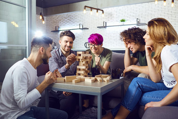 A cheerful group of friends play board games in the room.