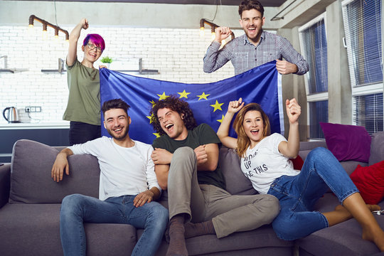 A group of friends with a European flag at a party. Friends celebrate the day of Europe.