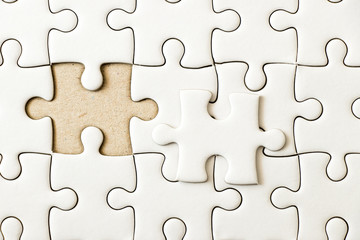 Obraz premium Closed up background of white plain jigsaw wait missing piece to match or fulfill