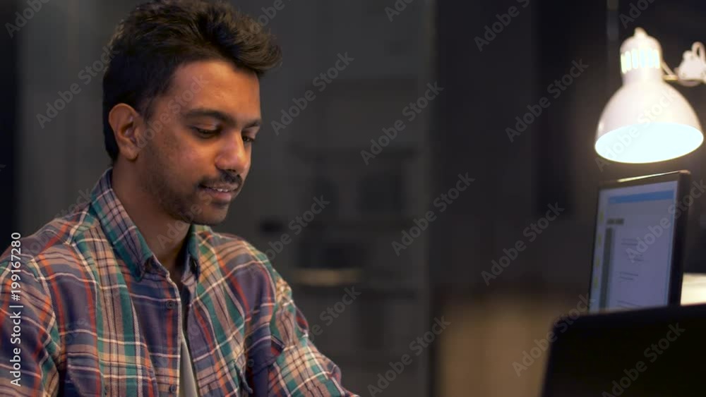 Poster deadline, technology and people concept - creative man or programmer with computer working at night 