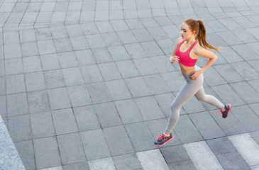 Fototapeta na wymiar Young woman jogging in city copy space