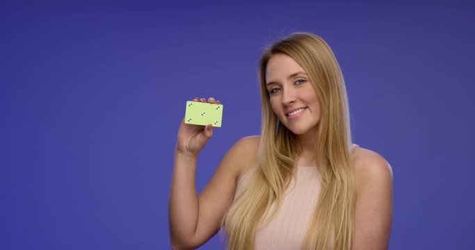 Portrait of a beautiful Woman holding a blank Card into the Camera and giving an stunning Smile