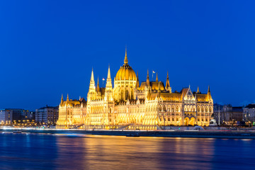 Fototapeta na wymiar Famous Budapest parliament at the river Danube during blue hour from the side