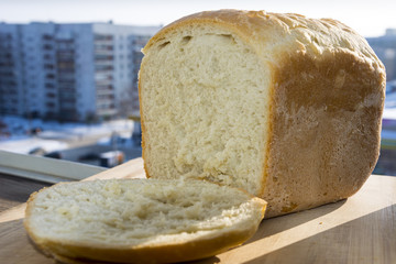 White homemade bread  with a piece on the window.