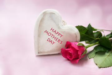 heart of wood and a rose on a pink background,  text Happy Mother's Day