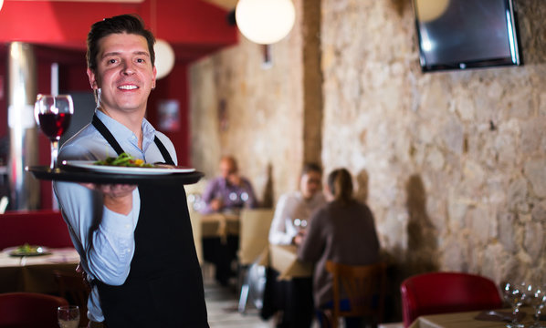 Waiter holding tray at restaurant
