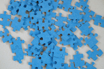 Blue jigsaw puzzle pieces on gray background