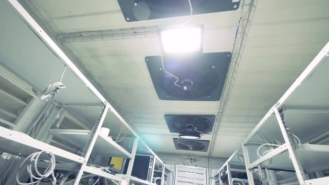 Row of bitcoin miners set up on the wired shelfs. Mining cryptocurrency concept. Bitcoin farm. Machines for mining cryptocurrency, bitcoin.